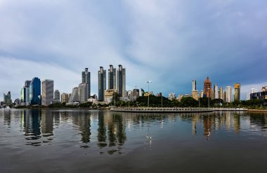 Benchakitti Parkı 'ndaki Ratchada Gölü' nün bulutlu öğleden sonrası manzarası. Benjakitti Parkı 'ndaki Bangkok şehir manzarası.