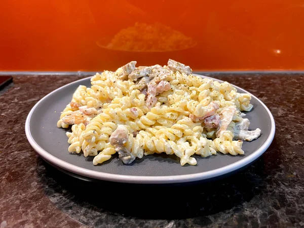 Fusilli Pasta White Cream Sauce Mushrooms Bacon Gray Plate Orange — Foto de Stock