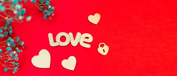 Sztandar. Słowo miłość w języku angielskim jest wykonane z drewna na czerwonym tle. Po lewej są kwiaty. Koncepcja: Walentynki, 8 marca, ślub. Minimalizm. — Zdjęcie stockowe