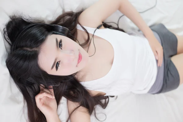 Jonge vrouw luisteren muziek in hoofdtelefoon — Stockfoto