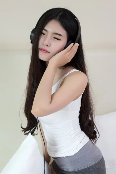 Mujer joven escuchando música en auriculares —  Fotos de Stock