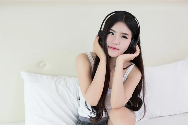 Młoda kobieta słuchająca muzyki w słuchawkach — Zdjęcie stockowe