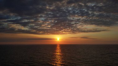 Okyanusun üzerinde yakıcı günbatımı. İnanılmaz bulutlar. Doğa boyaları. Deniz seyahati kavramı