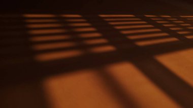 Gün batımında duvardaki panjurların gölgesi