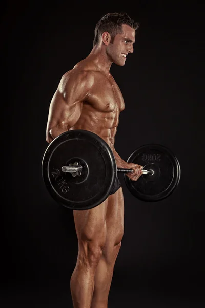 Bodybuilder killen gör övningar med stor hantel — Stockfoto