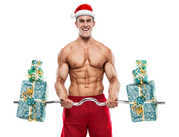 Мускулистый Санта Клаус делает упражнения с подарками над белым бэкгом — стоковое фото