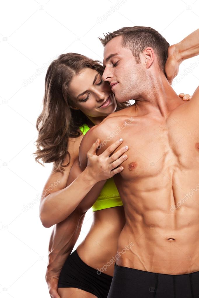 sexy couple, muscular man holding a beautiful woman isolated on 