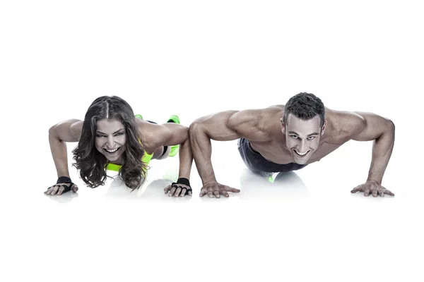Beautiful fitness young sporty couple doing pushups — Stock Photo, Image