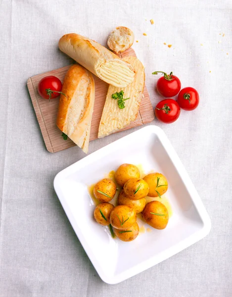 Gekochte Kartoffeln mit Baguette und Gemüse — Stockfoto