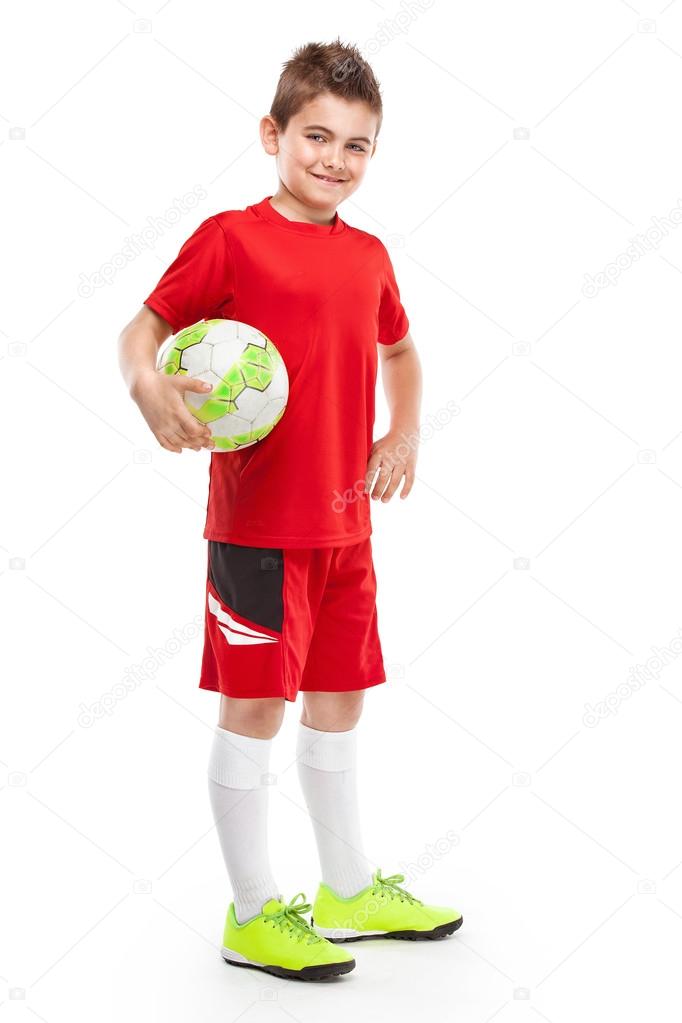 standing young soccer player holding football