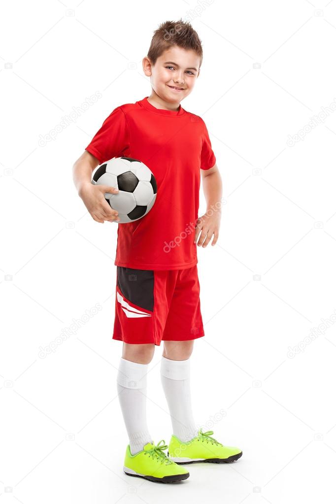 standing young soccer player holding football