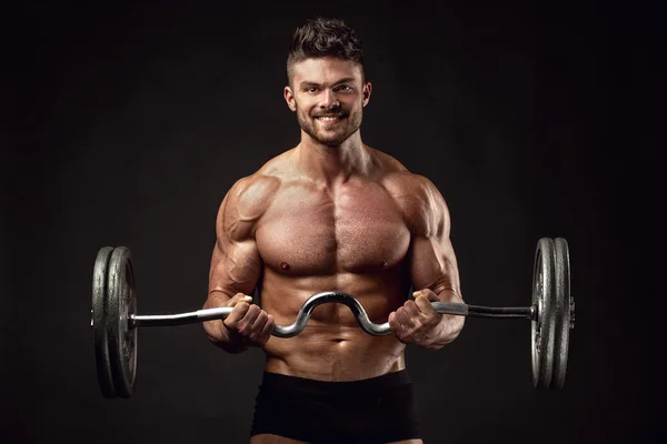 Muscular bodybuilder guy doing exercises with big dumbbell — Stock Photo, Image