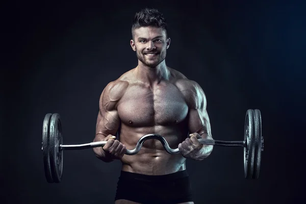 Muscular bodybuilder guy doing exercises with big dumbbell — Stock Photo, Image