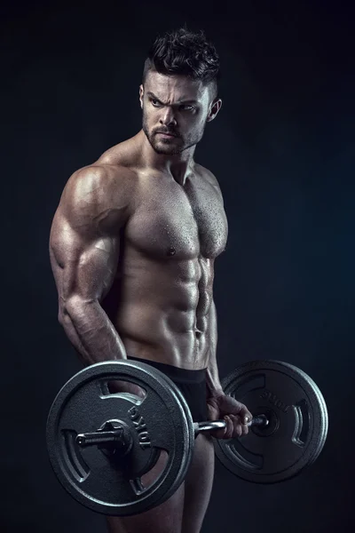 Kaslı vücut geliştirmeci adam büyük dumbbell ile yapıyor