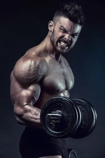 Musculoso musculoso cara fazendo exercícios com grande haltere — Fotografia de Stock