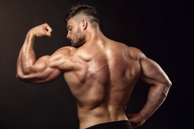 Güçlü atletik erkek Fitness Model sırt kasları, triceps poz,