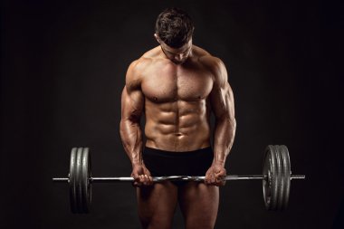 Kaslı vücut geliştirmeci adam büyük dumbbell ile yapıyor