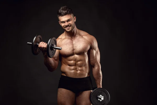 Gespierde bodybuilder man doen oefeningen met halters — Stockfoto