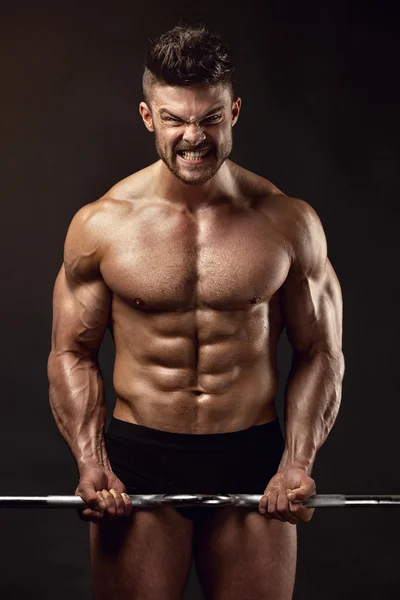 Muskulöser Bodybuilder, der Übungen mit großer Hantel macht — Stockfoto