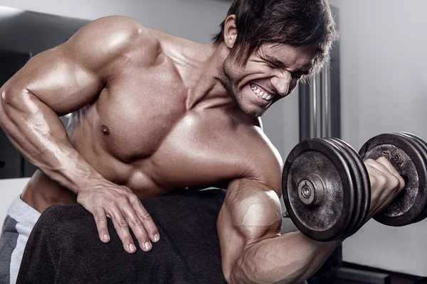 Joven muscular sexy hombre entrenamiento en gimnasio — Foto de Stock