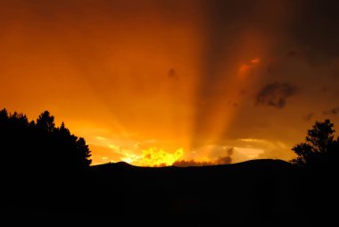 Gün batımı gökyüzü ufuktan turuncu ışınları gösteriyor..