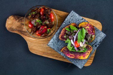 Dilimlenmiş sığır eti barbeküsü çizgili biftek ve salata yanında domates ve roka.