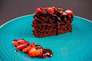 Çilekli çikolatalı pasta turkuaz tabakta, yakın plan.