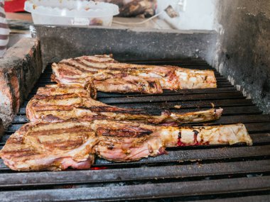 Tomahawk bifteği alevli, siyah ızgarada.