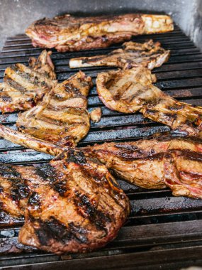 Tomahawk bifteği alevli, siyah ızgarada.