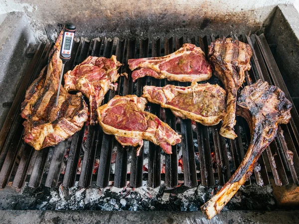 Tomahawk rib beef steak on hot black grill with flames