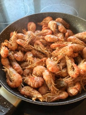 Lezzetli bir akşam yemeği. Büyük bir tavada pişmiş karides.