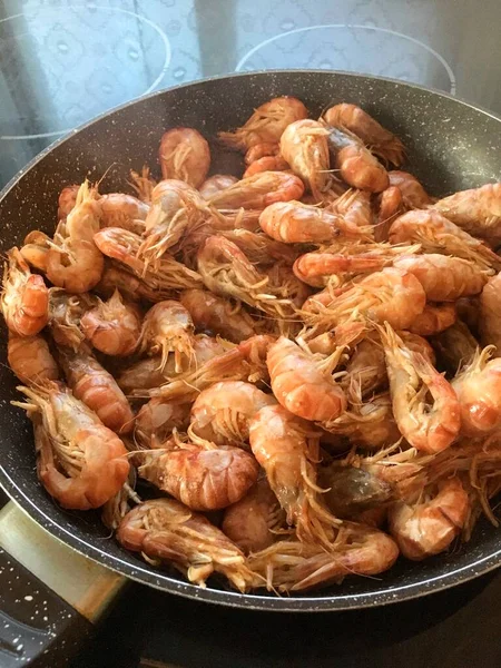 Lezzetli bir akşam yemeği. Büyük bir tavada pişmiş karides.