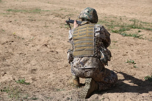 Bewaffneter Mann in Tarnung mit Gewehr in der Hand — Stockfoto