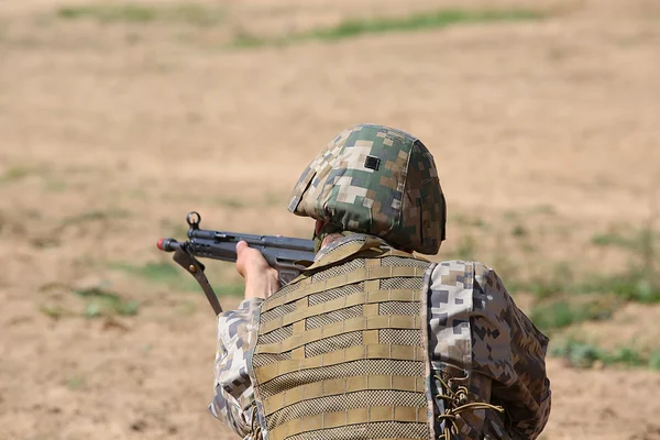 Homem armado em camuflagem com espingarda nas mãos — Fotografia de Stock