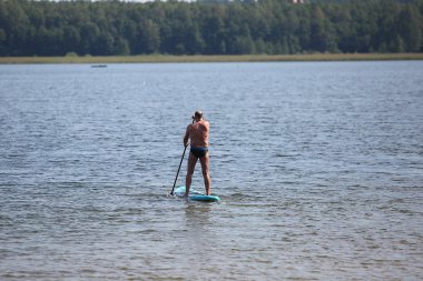Üst düzey erkek SUP tahta üzerinde egzersiz