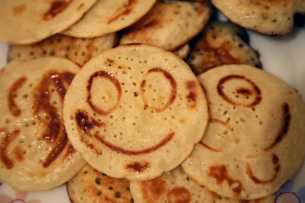 Los panqueques rubios con sonrisas en el plato — Foto de Stock