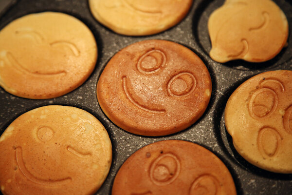 The ruddy pancakes with smiles on the pan