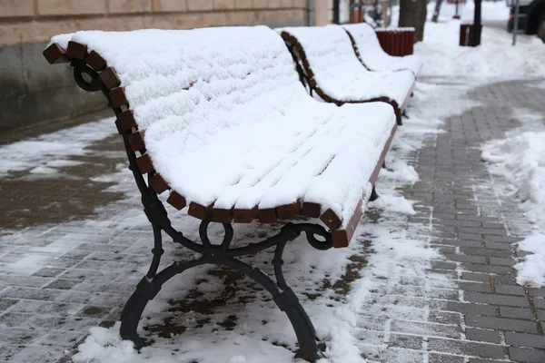 La panchina sulla strada coperta di neve. Orario invernale — Foto Stock
