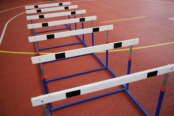 Fila de barreiras transversais no salão de atletismo — Fotografia de Stock