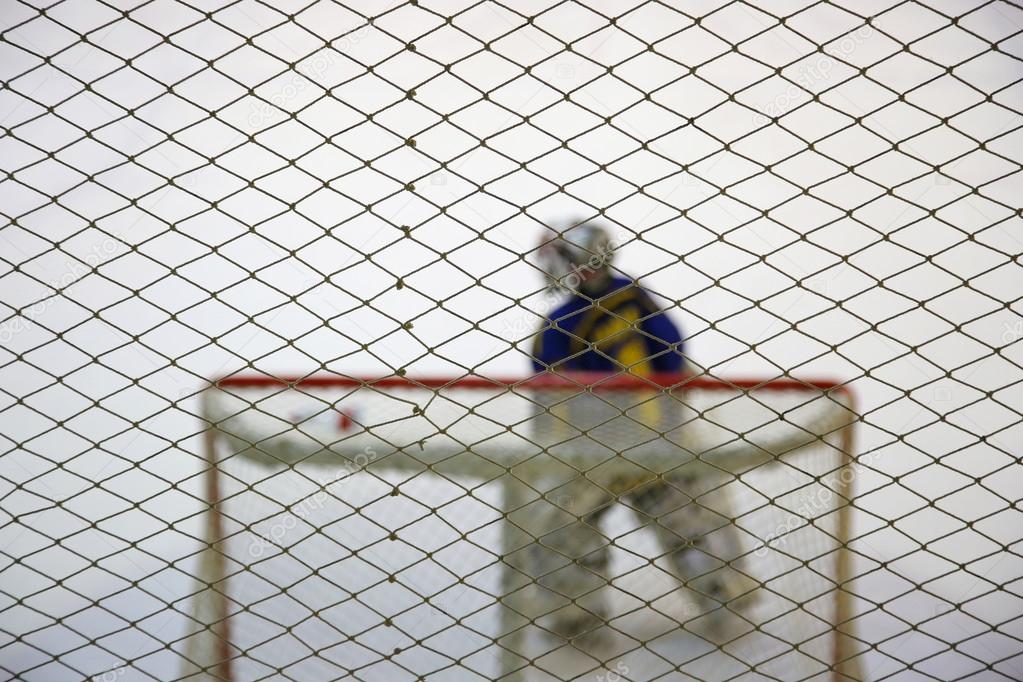 Ice hockey goalkeeper near gates on the ice