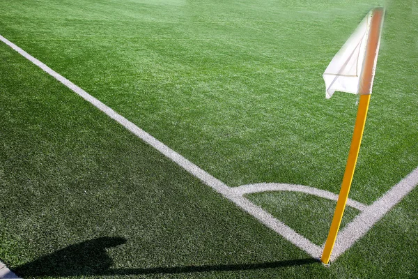 Bandeira na esquina do campo de futebol com sombra — Fotografia de Stock