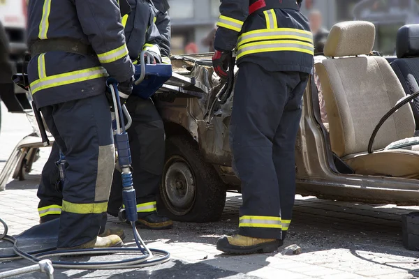 Bombeiros com as tesouras pneumáticas abrir as portas do carro — Fotografia de Stock