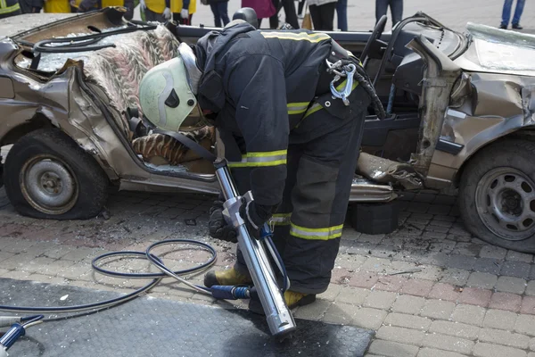 Bombeiros com as tesouras pneumáticas abrir as portas do carro — Fotografia de Stock