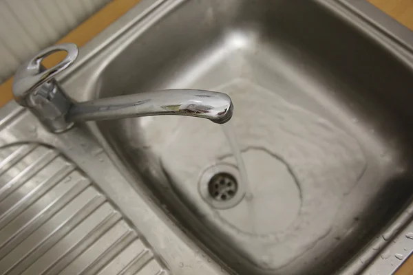 Grifo de agua de trabajo en una cocina — Foto de Stock