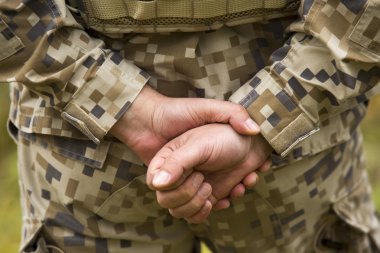 Military person holding hands behind his back