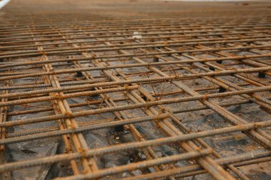 İnşaat alanında beton dökülmeye hazır bir yapı temeli için bağlantı demiri ızgarası hazır.