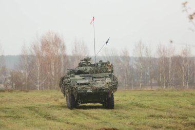 DAUGAVPILS, LATVIA - 10 Kasım 2025: Askeri Kararlı Savaşçı. Askeri tatbikat sırasında zırhlı araç sahaya çıkıyor.