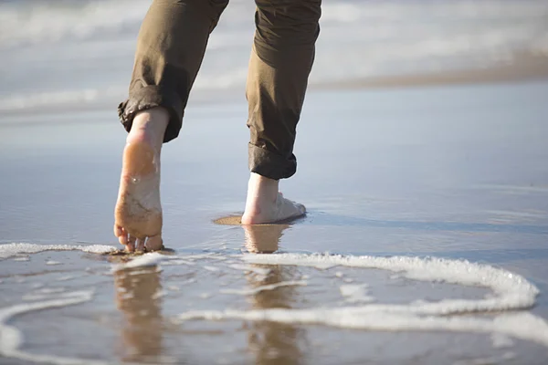 Woman's legs walking by sea shore — Stock Photo, Image