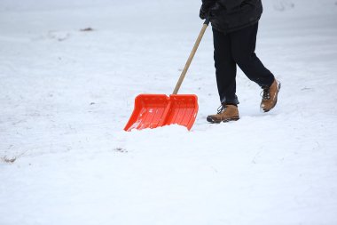Adam kar küreği ile kaldırımlar temizler