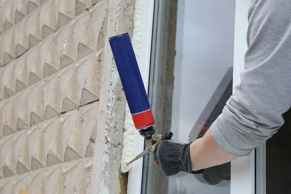 La mano del trabajador fijan la ventana por la espuma de poliuretano —  Fotos de Stock